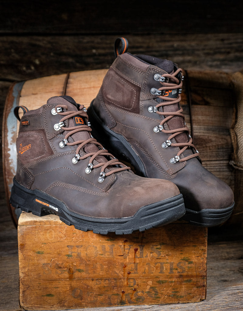 Pair of brown work boots on a wooden block with a rustic background
