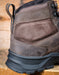 Brown leather boot with black sole on a wooden surface