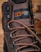 Brown boot with DCS (Danner Comfort System) label on a wooden background