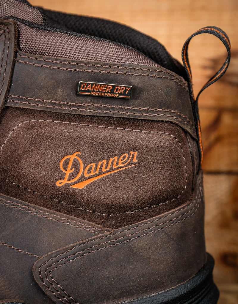 Close-up of a Danner boot with visible logo stating 'Danner Dry waterproof' on a wooden background