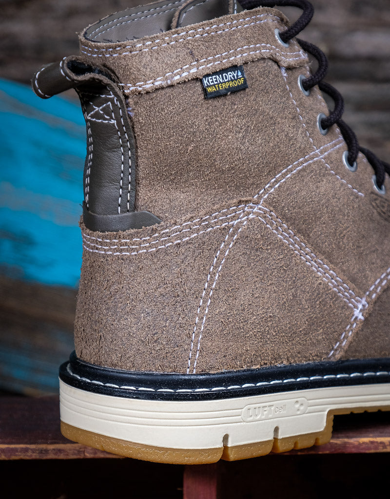 Close-up of a brown boot with visible KeenDry Waterproof logo on a blurred background