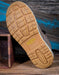 Close-up of a shoe sole with Keen logo on a wooden surface
