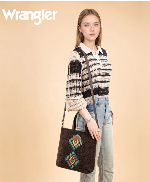 Woman holding a patterned bag with 'Wrangler' branding on a beige background