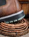 Brown leather boot with a TPU sole stepping on coiled brown basket